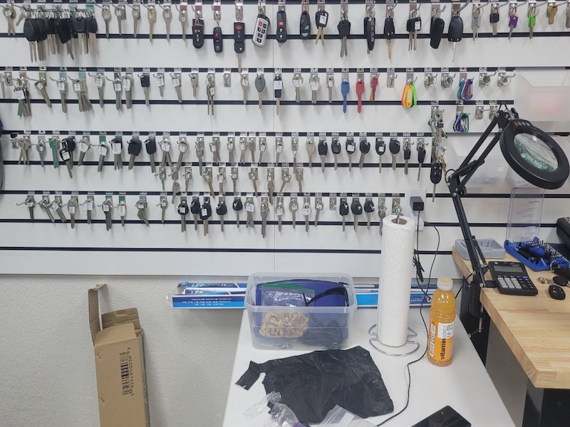 Some keys and fobs on shelf at the store.